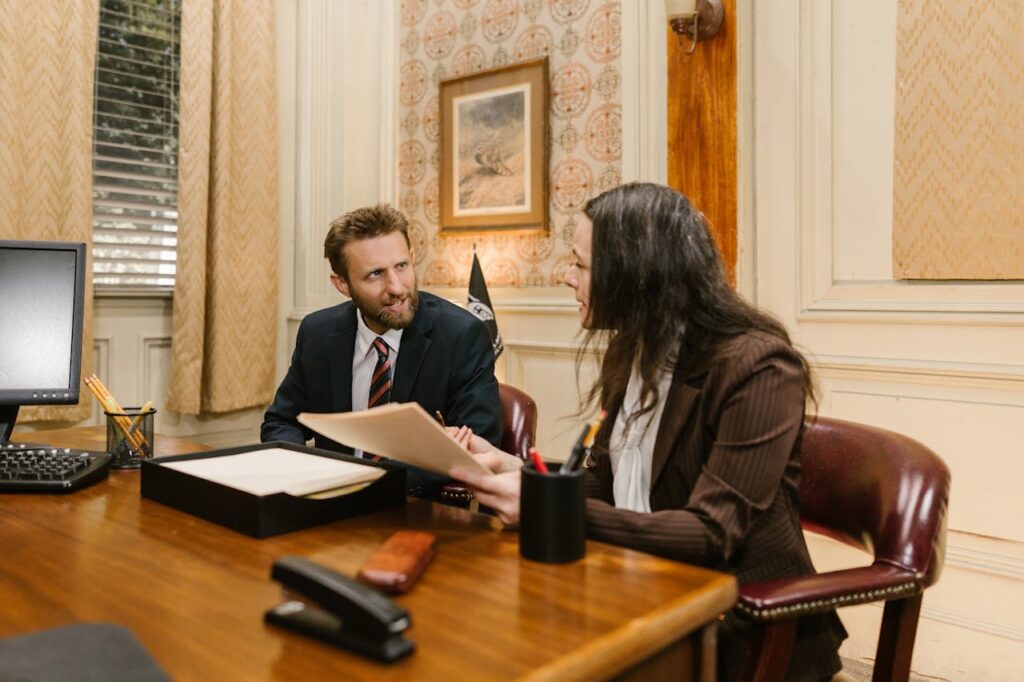 Mastering the First Impression: Your intriguing post title goes here Two professionals engaged in a business discussion in an office setting, reviewing legal documents.