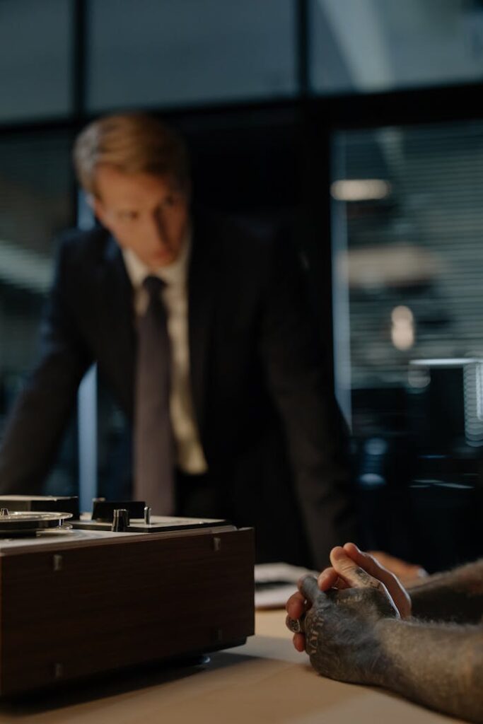 Crafting Captivating Headlines: Your awesome post title goes here A tense interrogation scene with blurred detective and suspect's clasped hands.